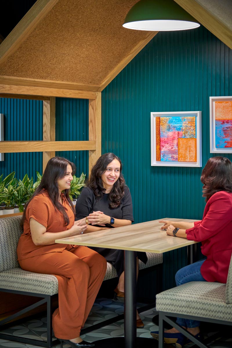 Close-up of three colleagues seated at table during discussion.