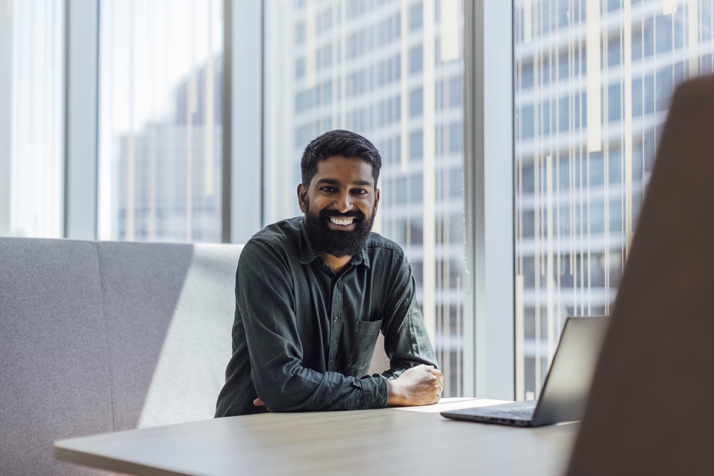 bp employee with laptop in office by city skyline, highlighting careers, innovation, and opportunities.