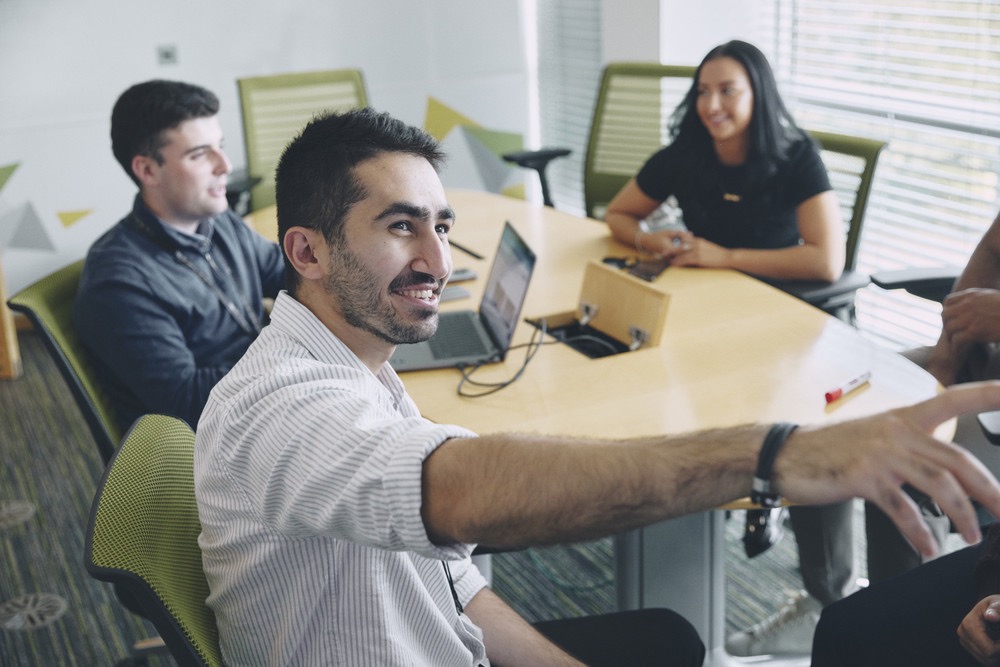 Colleagues gathered around a conference table engaged in discussion.