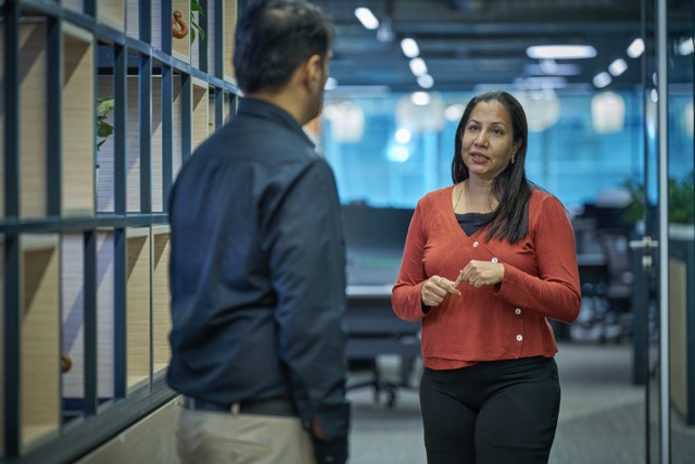 Two colleagues having a discussion in a modern office setting.