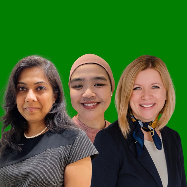 Three women posing for professional team portrait on green background.