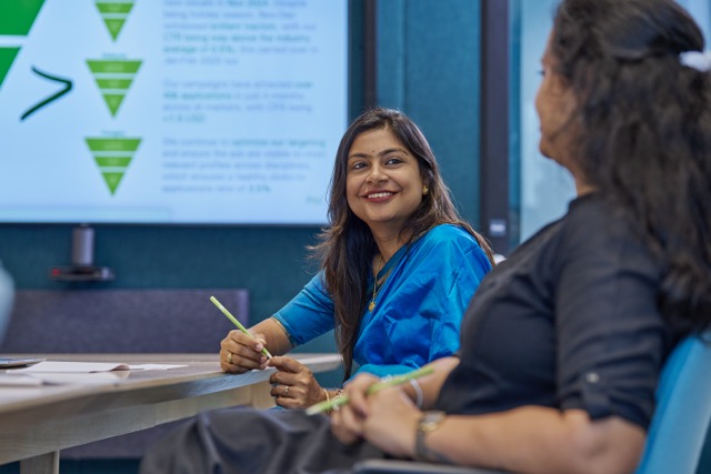 bp employees in a meeting room discussing strategy with presentation screen, highlighting collaboration and leadership.