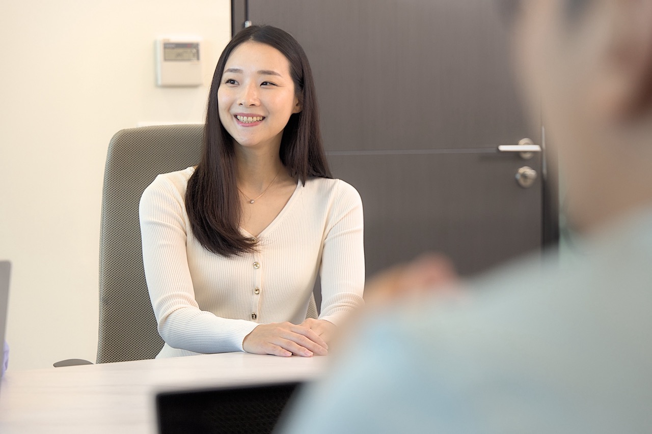 Smiling professional woman in a business meeting setting, symbolizing workplace diversity and career growth.