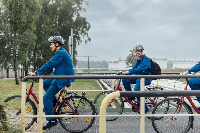 bp employees cycling with helmets on site, highlighting sustainable mobility and workplace safety.