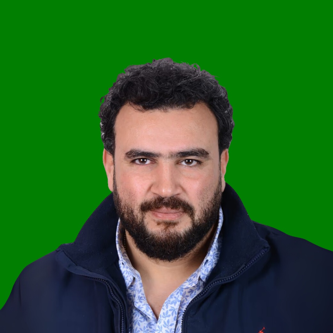 Professional headshot of man with beard on green background.