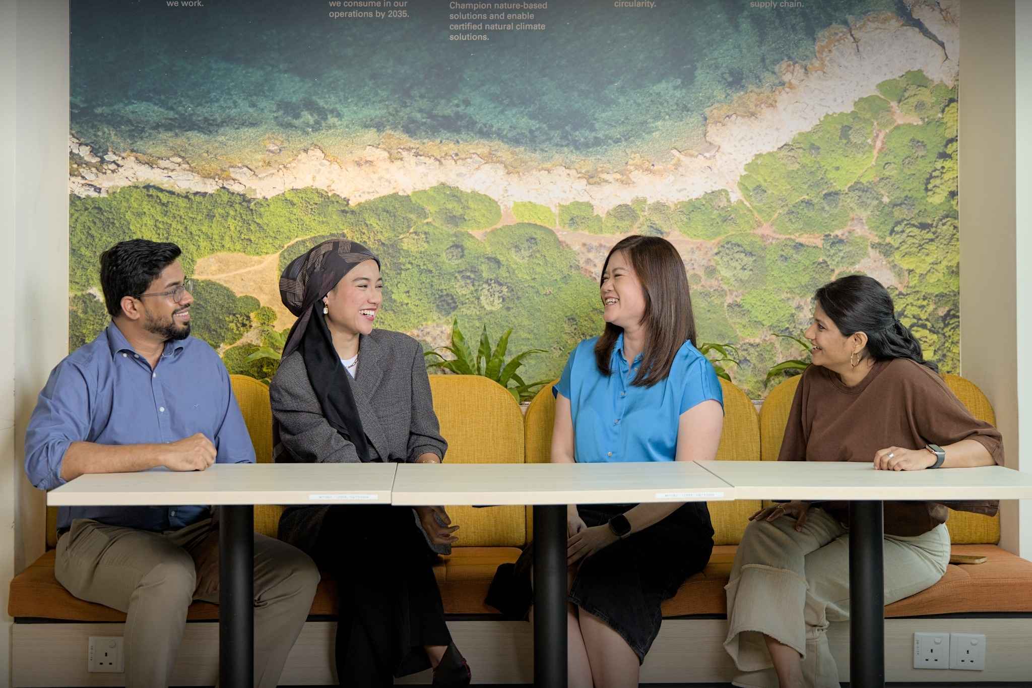 Group of colleagues sitting together and smiling during a casual office meeting.
